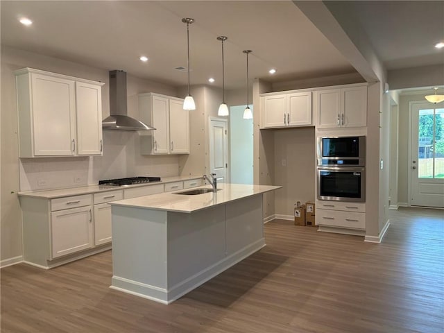 30 Riverrock Trl, Dallas, GA 30157 - kitchen featuring stainless steel appliances, wall chimney range hood, white cabinetry, wood finished floors, and recessed lighting
