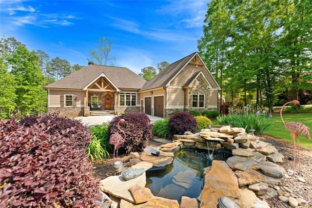 274 Ramey Rd, Westminster, SC 29693 - view of front facade featuring stone siding, an attached garage, driveway, and a garden pond