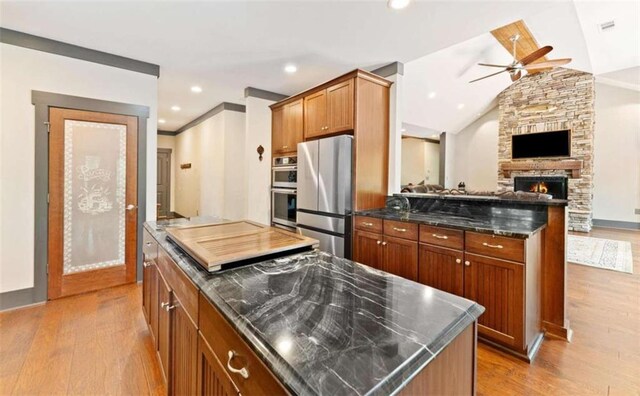 274 Ramey Rd, Westminster, SC 29693 - kitchen featuring appliances with stainless steel finishes, ceiling fan, light wood finished floors, brown cabinets, and lofted ceiling