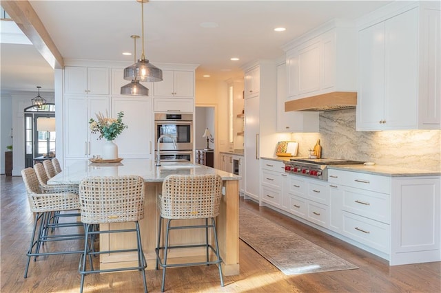 kitchen with wood finished floors, appliances with stainless steel finishes, backsplash, and white cabinetry