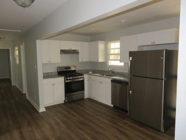 kitchen with dark wood-type flooring, sink, white cabinetry, light stone counters, and appliances with stainless steel finishes