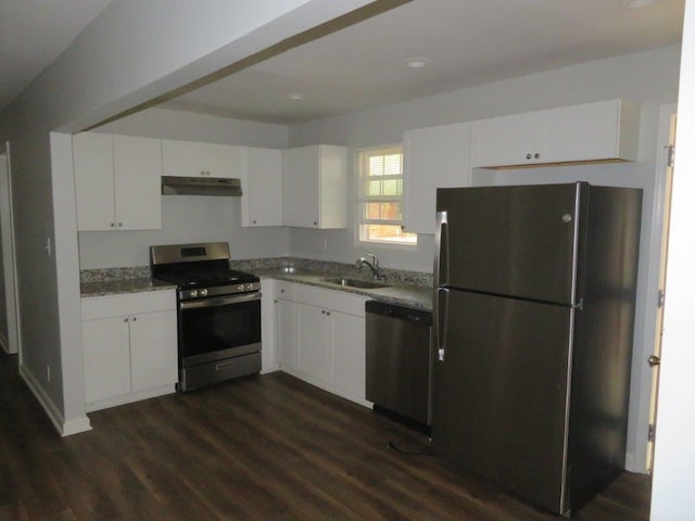 kitchen with sink, white cabinetry, dark hardwood / wood-style flooring, stainless steel appliances, and light stone countertops