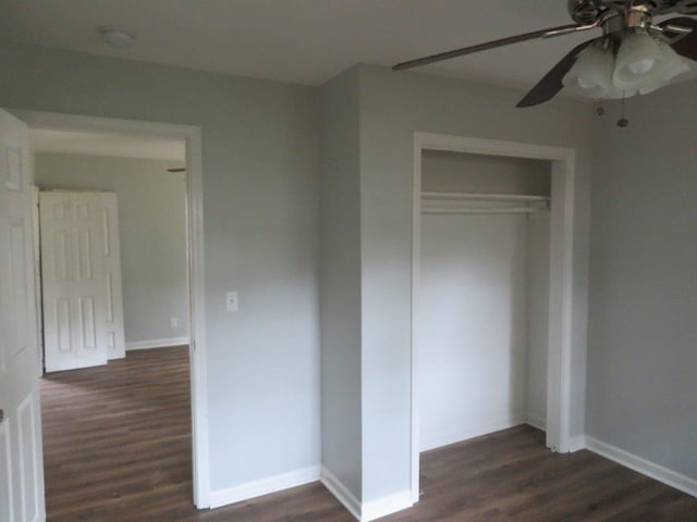 unfurnished bedroom featuring ceiling fan, dark hardwood / wood-style flooring, and a closet