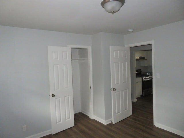 unfurnished bedroom with dark hardwood / wood-style floors and a closet