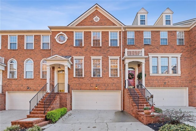 multi unit property with a garage, concrete driveway, and brick siding