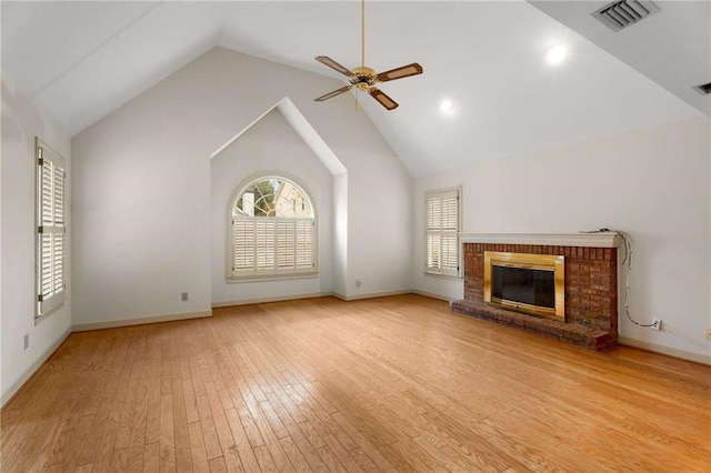 unfurnished living room featuring ceiling fan, a brick fireplace, high vaulted ceiling, and light hardwood / wood-style flooring