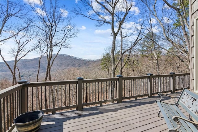 wooden terrace featuring a mountain view and a forest view