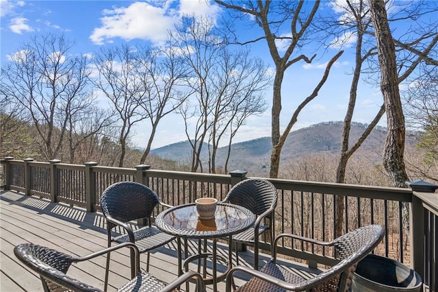 deck with outdoor dining space and a mountain view