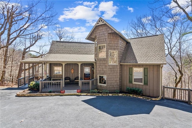 view of front facade featuring covered porch and a shingled roof