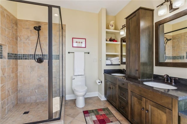 bathroom featuring a shower stall, toilet, double vanity, and a sink