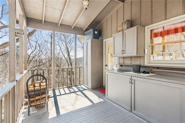 exterior space with white cabinetry, light countertops, light wood-style floors, and lofted ceiling