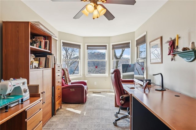 office space with light colored carpet, baseboards, and ceiling fan