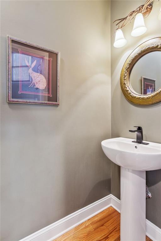 bathroom with a sink, baseboards, and wood finished floors