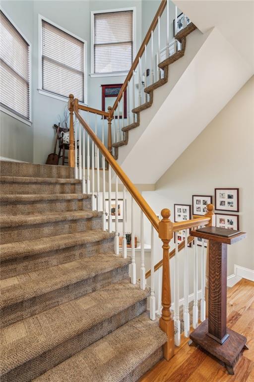 staircase with baseboards and wood finished floors