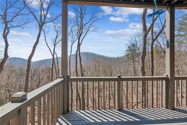 wooden terrace with a view of trees and a mountain view