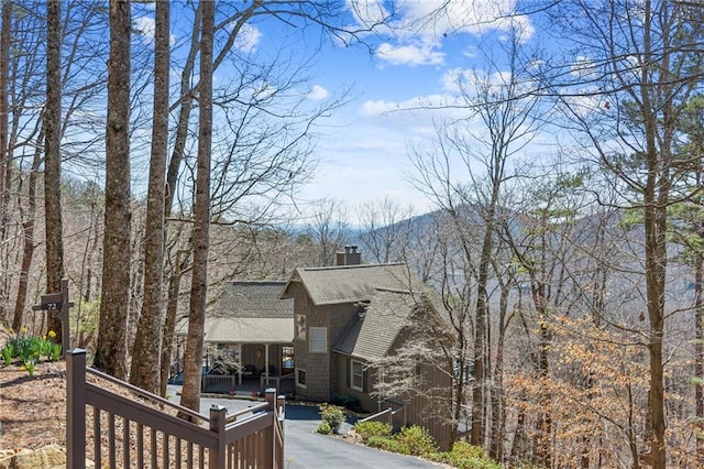 exterior space with a chimney and a shingled roof