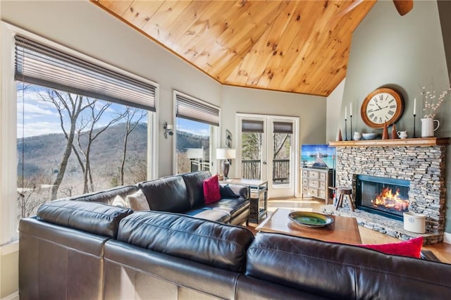 living room featuring a stone fireplace, wood ceiling, french doors, and high vaulted ceiling