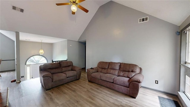living area featuring visible vents, ceiling fan, light wood-style flooring, and high vaulted ceiling