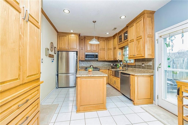 kitchen with pendant lighting, stainless steel appliances, a wealth of natural light, light stone countertops, and a kitchen island