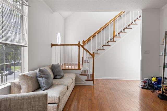 living room with a textured ceiling, hardwood / wood-style flooring, and crown molding