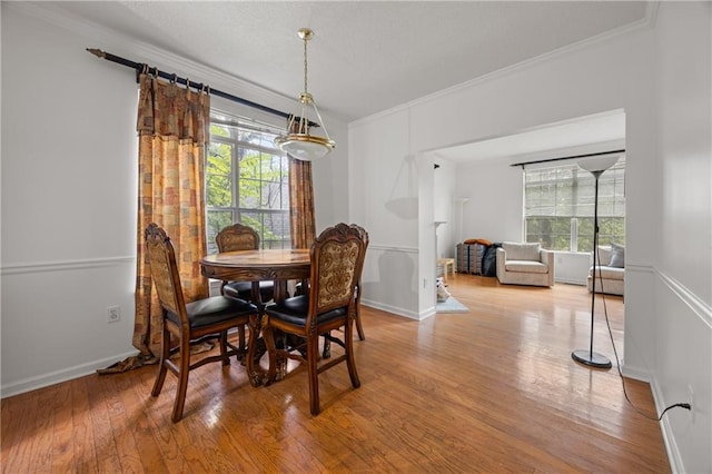 dining room featuring ornamental molding, light hardwood / wood-style flooring, and a wealth of natural light