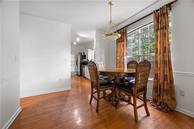 dining area with vaulted ceiling and hardwood / wood-style floors