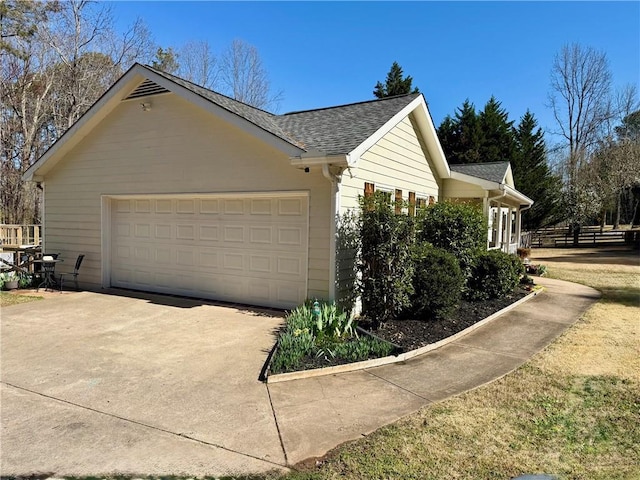 view of property exterior featuring concrete driveway, a garage, and roof with shingles