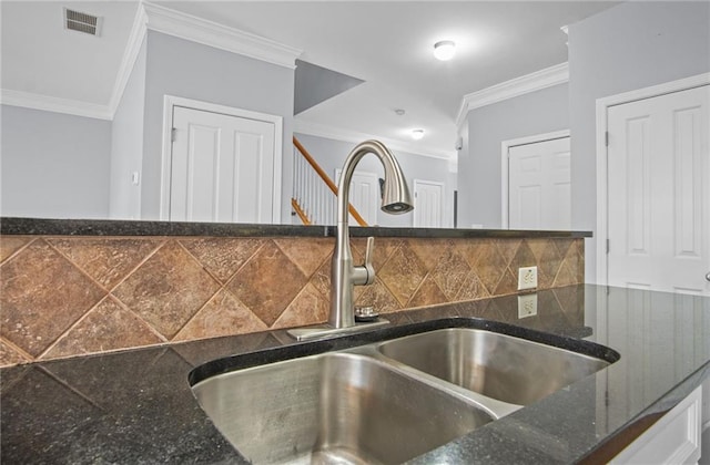 room details featuring visible vents, ornamental molding, decorative backsplash, dark stone countertops, and a sink