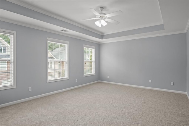 unfurnished room featuring a ceiling fan, baseboards, crown molding, a raised ceiling, and light colored carpet