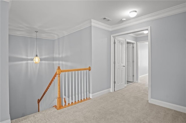 corridor with an upstairs landing, ornamental molding, baseboards, and carpet floors