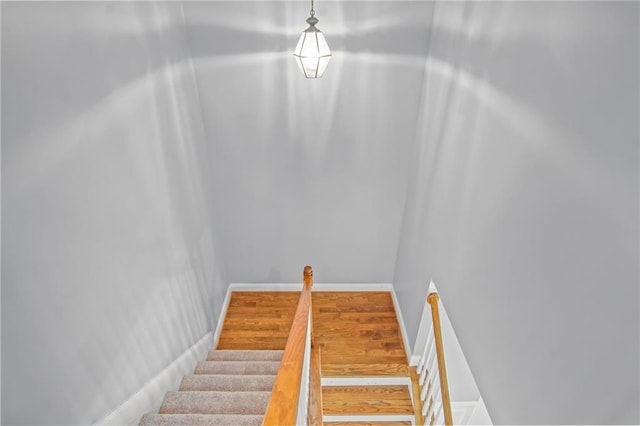 staircase with baseboards and wood finished floors