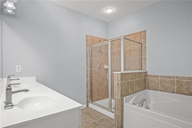 bathroom featuring tile patterned flooring, a shower stall, a garden tub, and a sink