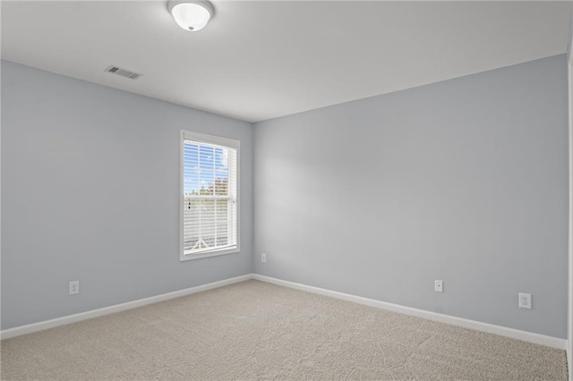 carpeted empty room with visible vents and baseboards