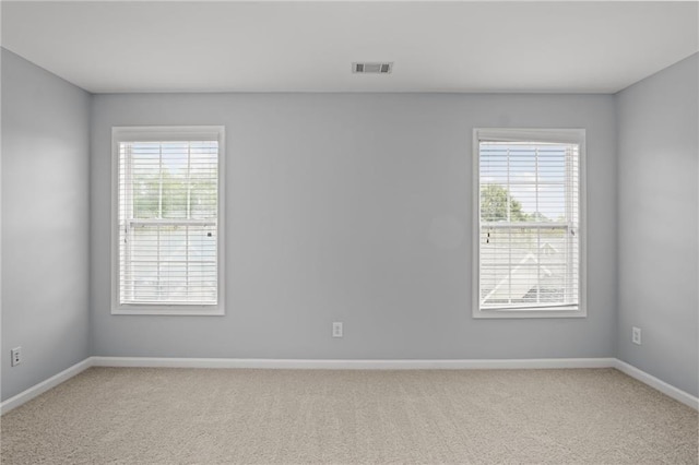 spare room featuring visible vents, baseboards, and carpet