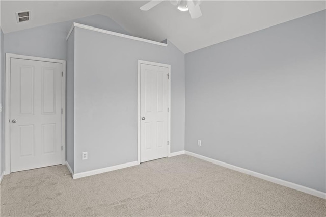 unfurnished bedroom featuring visible vents, baseboards, carpet, and vaulted ceiling