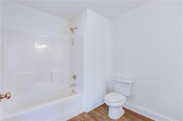 full bathroom featuring baseboards, shower / bath combination, toilet, and wood finished floors