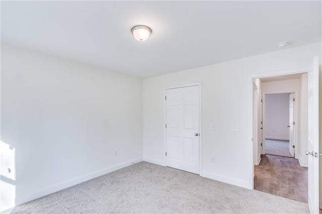 unfurnished bedroom featuring carpet flooring and baseboards