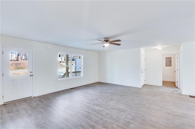 unfurnished living room with a ceiling fan, light wood-type flooring, electric panel, and baseboards