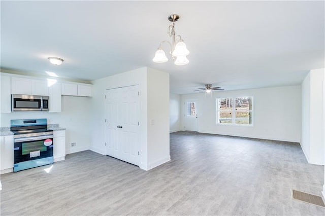 kitchen featuring appliances with stainless steel finishes, light wood-type flooring, white cabinets, and visible vents