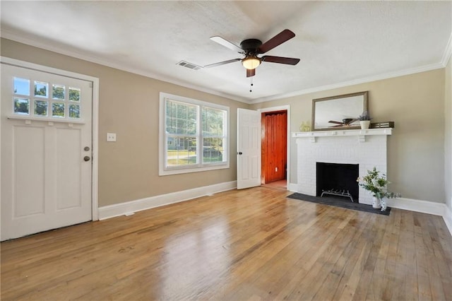 unfurnished living room with a fireplace, light hardwood / wood-style floors, a wealth of natural light, and crown molding