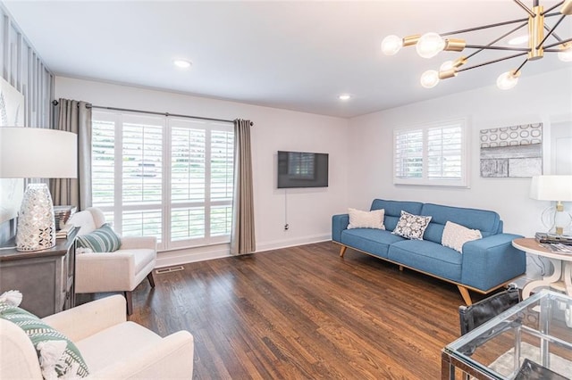 living room with visible vents, baseboards, plenty of natural light, and wood finished floors