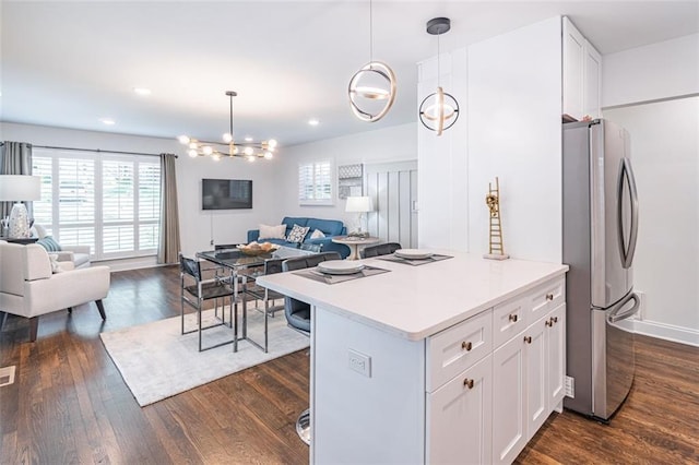 kitchen with white cabinets, dark wood-style flooring, open floor plan, light countertops, and freestanding refrigerator