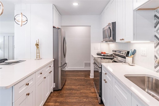 kitchen with visible vents, white cabinets, light countertops, dark wood finished floors, and stainless steel appliances