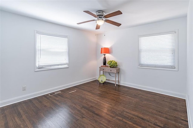 unfurnished room featuring a healthy amount of sunlight, ceiling fan, visible vents, and wood finished floors