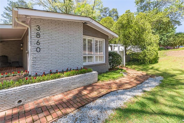 view of home's exterior featuring a yard and brick siding