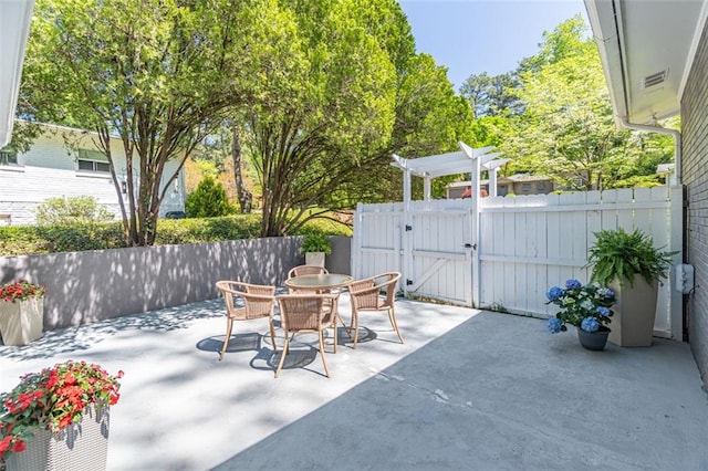 view of patio / terrace featuring a pergola, outdoor dining area, fence, and a gate