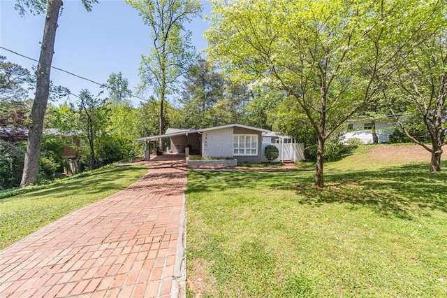 view of front of property featuring a front yard, an attached carport, and decorative driveway