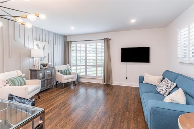 living room with baseboards, recessed lighting, an inviting chandelier, and wood finished floors