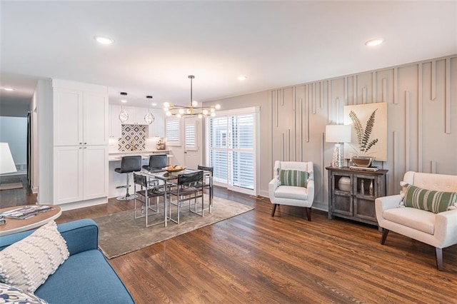living area with dark wood-style flooring, recessed lighting, and a chandelier