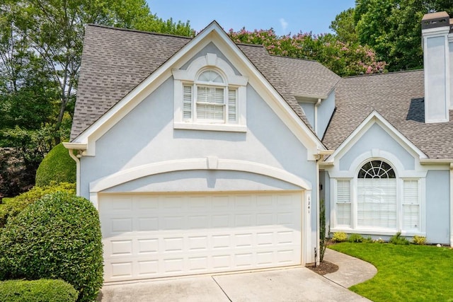 1241 Newbridge Trce, Brookhaven, GA 30319 - view of front of home with a shingled roof, stucco siding, driveway, a front lawn, and a chimney